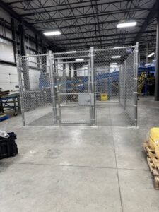An industrial chain link security cage installed inside a warehouse by Bostwick Fencing, LLC in Sioux City, IA.