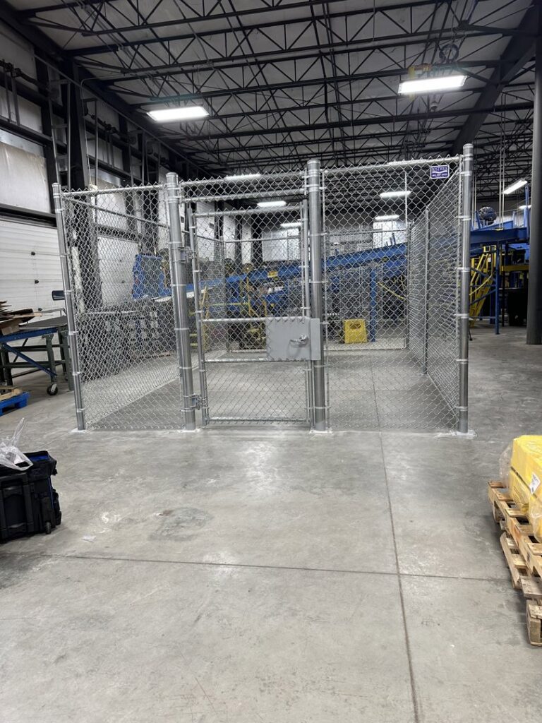 An industrial chain link security cage installed inside a warehouse by Bostwick Fencing, LLC in Sioux City, IA.