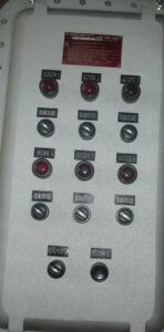 An industrial control panel with multiple "Auger" and "Disable/Enable" buttons, representing electrical control work by Basic Supply in Lafayette, LA.