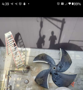 A large industrial cooling tower fan blade on the ground, ready for installation or repair by CMC Mechanical in Goose Creek, SC.