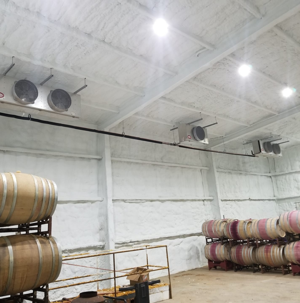 Industrial cooling units installed on the ceiling of a facility with wine barrels by Klimate Concepts in Lubbock, TX.
