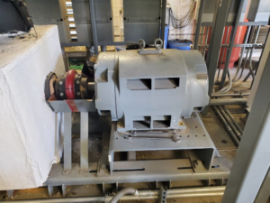 An industrial electric motor undergoing repair with tools visible at Caddell Electric Co Inc in Dallas, TX