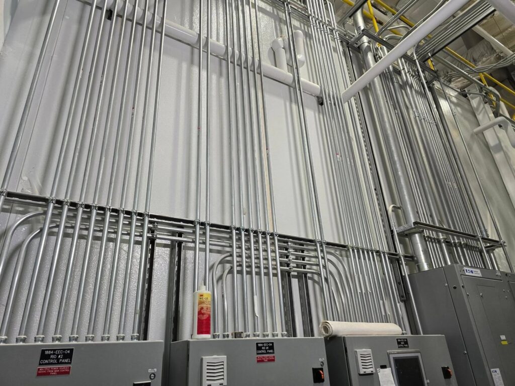 Multiple runs of electrical conduit expertly installed on a wall in an industrial setting by Trademark Elite Electrical Services in Butte, MT