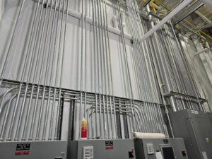 Multiple runs of electrical conduit expertly installed on a wall in an industrial setting by Trademark Elite Electrical Services in Butte, MT