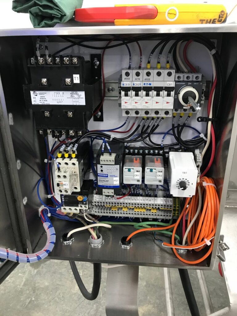 Open industrial electrical control panel with complex wiring and circuit breakers by T.S.F Electric in Saco, ME.