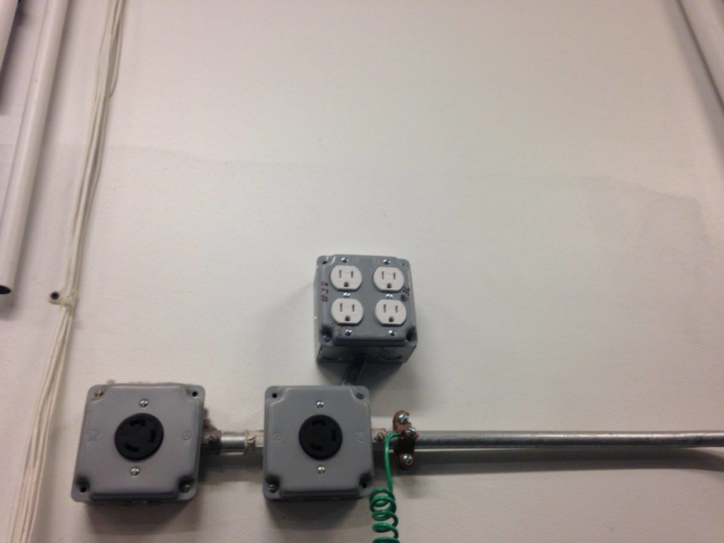 Industrial electrical outlets and conduit installed on a white wall by RightWay Electric RI in Providence, RI.
