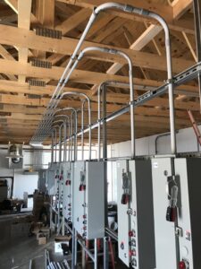 Industrial electrical panel and conduit installation in a commercial building by Apex Electrical Solutions in Minot, ND.