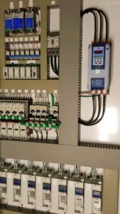 A complex industrial electrical panel with neatly wired components, installed by Progressive Electrical Services, Inc. Lee, NH.