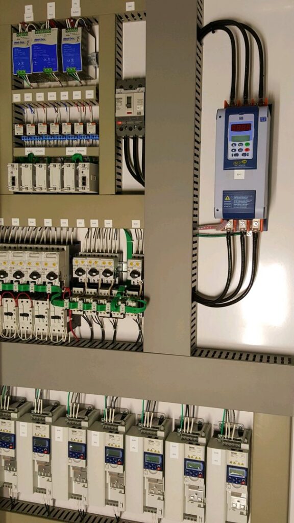 A complex industrial electrical panel with neatly wired components, installed by Progressive Electrical Services, Inc. Lee, NH.