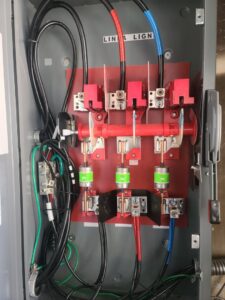 Interior view of an industrial electrical panel with fuses and wiring by TOTAL Electric LLC in Fayetteville, NC.