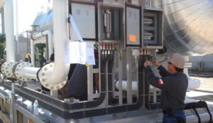 An electrician working on industrial electrical panels and controls, demonstrating expertise from AK Electrical, LLC in Mesquite, TX.