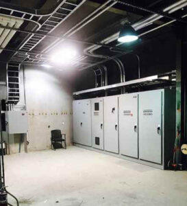 An industrial electrical room with multiple control panels and cable trays installed by Progressive Electrical Services, Inc. Lee, NH.