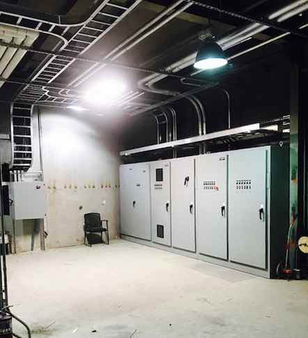 An industrial electrical room with multiple control panels and cable trays installed by Progressive Electrical Services, Inc. Lee, NH.