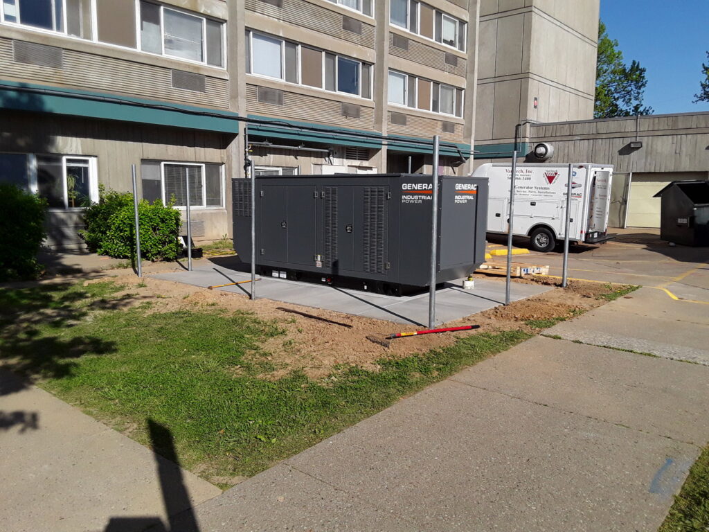 A newly installed Generac industrial power generator at a job site with a Varitech, Inc. service truck in Louisville, KY.