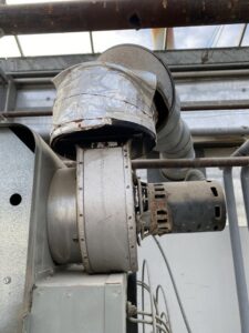 An industrial HVAC blower motor and ductwork, part of a system serviced by Service Champions Heating & Cooling in Aurora, IL.