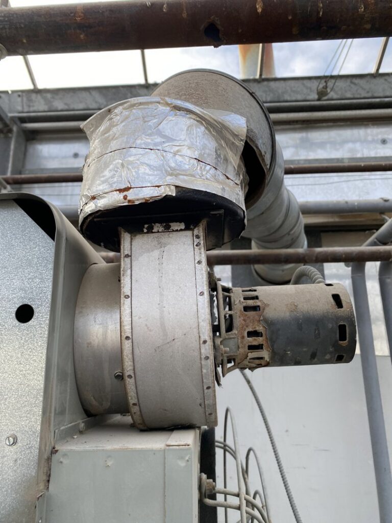 An industrial HVAC blower motor and ductwork, part of a system serviced by Service Champions Heating & Cooling in Aurora, IL.