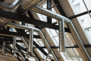 Industrial HVAC spiral ductwork installation in a building with high ceilings by DC AC Air Conditioning & Heating in San Diego, CA.