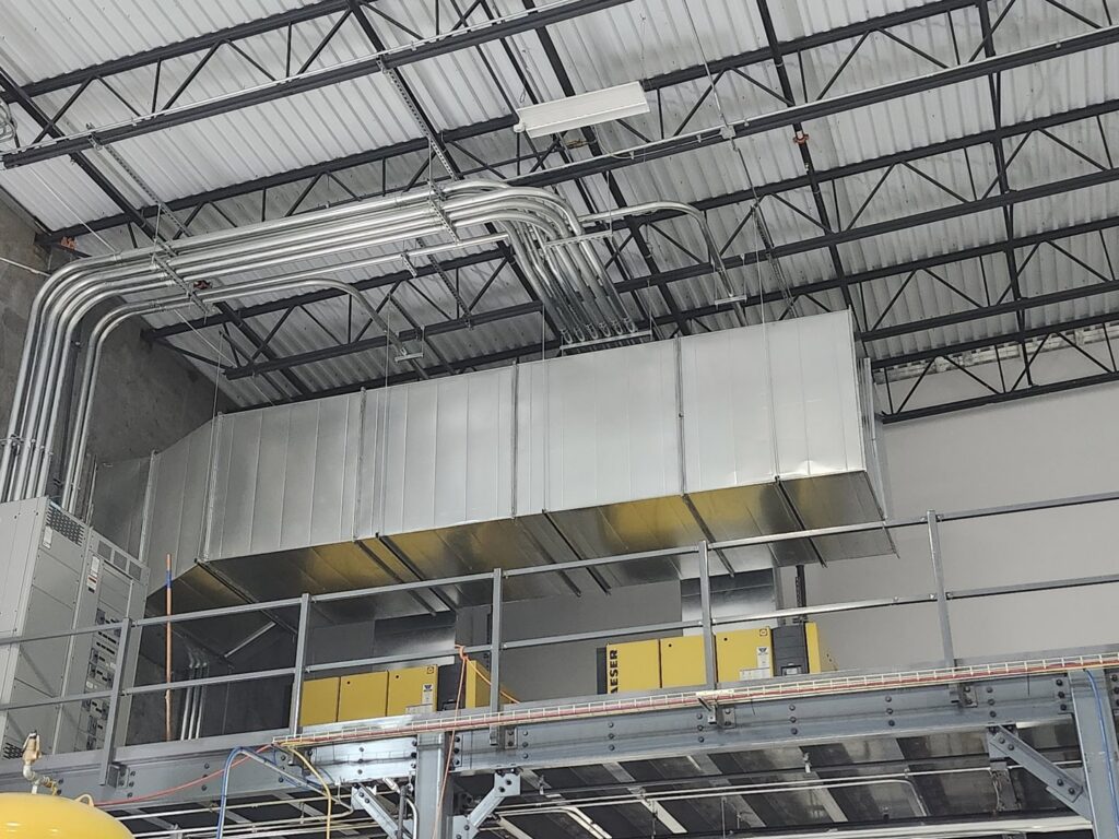 Large industrial HVAC ductwork and electrical conduits installed in a commercial building by SBS-NC, LLC in High Point, NC