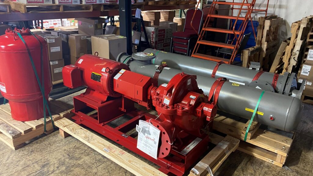 Large red industrial HVAC pumps and grey tanks on pallets in a warehouse at Thermoflo Equipment in Pittsburgh, PA
