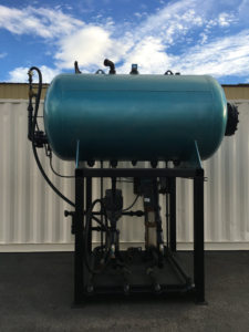 A large industrial pressure vessel with pumps and piping, part of a boiler system from Holbrook Servco Boiler Service & Sales in Salt Lake City, UT.