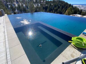 A stunning infinity-edge pool with an integrated spa, showcasing custom pool construction by Wetworks Pool and Spa in Englewood, CO.