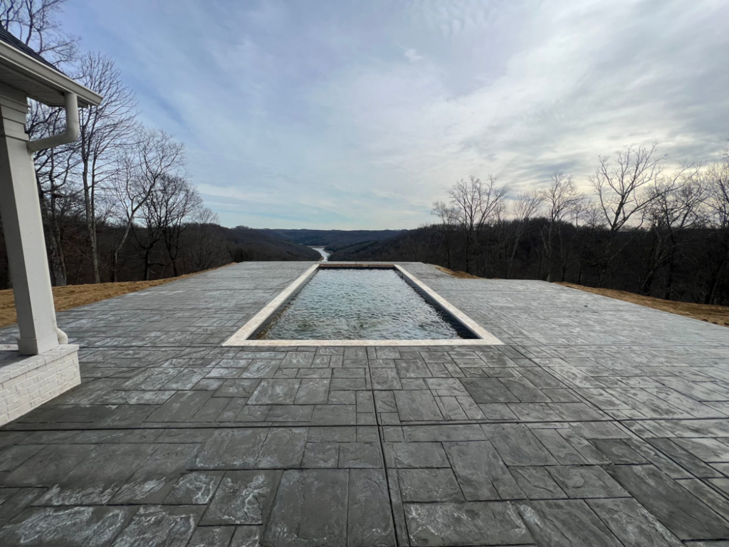 An elegant infinity-edge pool offering a breathtaking scenic view, expertly built by Luxury Outdoors in Murfreesboro, TN.