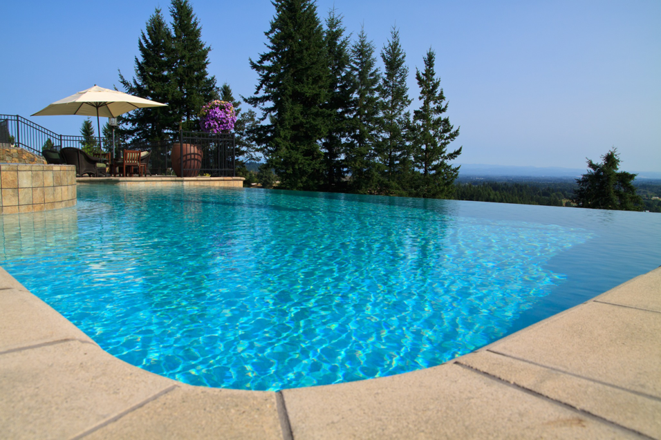 An infinity-edge swimming pool with a stunning valley view, designed and built by Anderson Poolworks in Wilsonville, OR.
