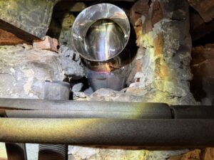 An interior view of a chimney flue with a newly installed metal liner by Certified Masons in Warwick, RI
