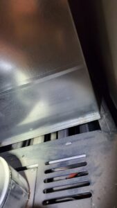 A close-up view inside an HVAC furnace, showing the heat exchanger or burner area, serviced by Hicken Air in Gilbert, AZ