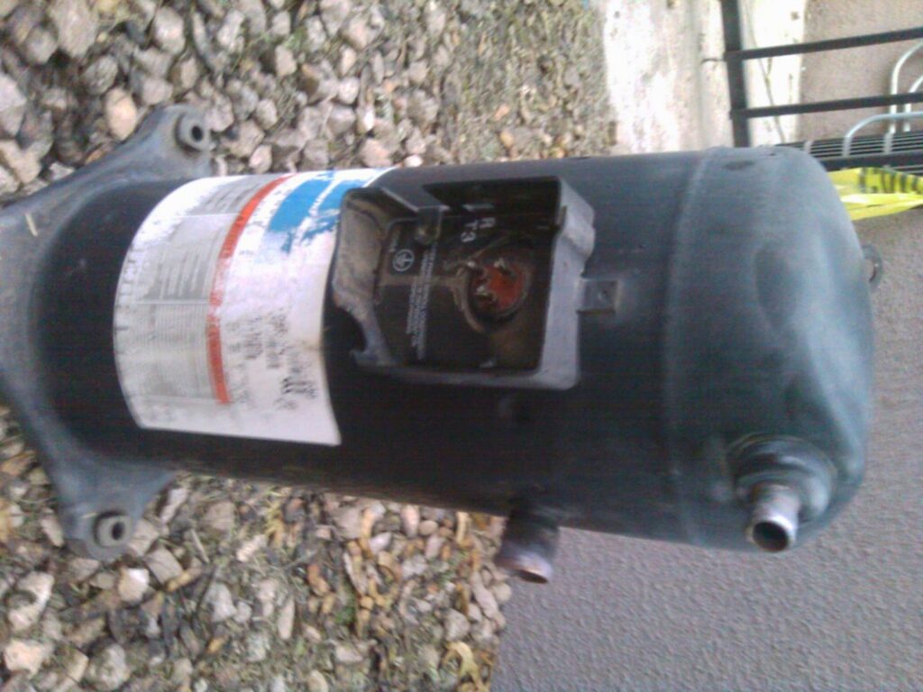 Inside an outdoor air conditioning unit, showing the compressor and refrigerant lines, serviced by J AND J HVAC L.L.C in Mesa, AZ