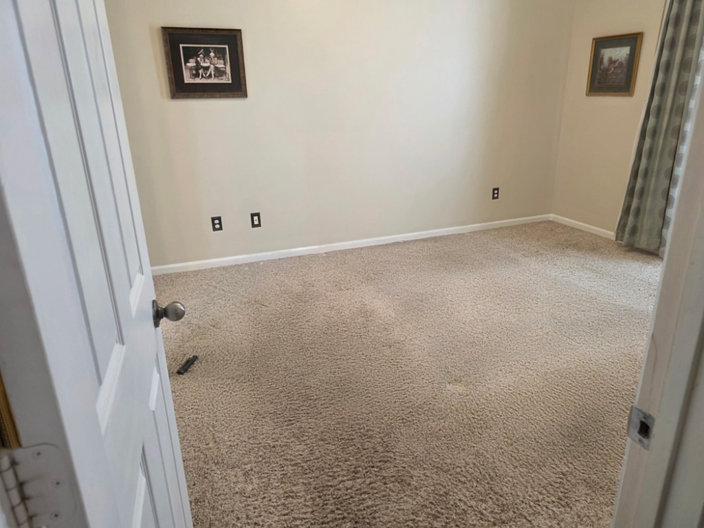 A newly installed light beige carpet in a bedroom by B.L.A Floors in Lafayette, LA.
