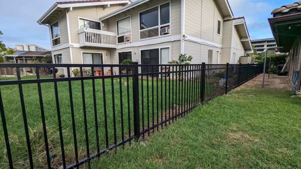 A newly installed black metal fence around a residential backyard by Upright Fencing Hawaii LLC in Kapolei, HI.