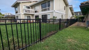 A newly installed black metal fence around a residential backyard by Upright Fencing Hawaii LLC in Kapolei, HI.