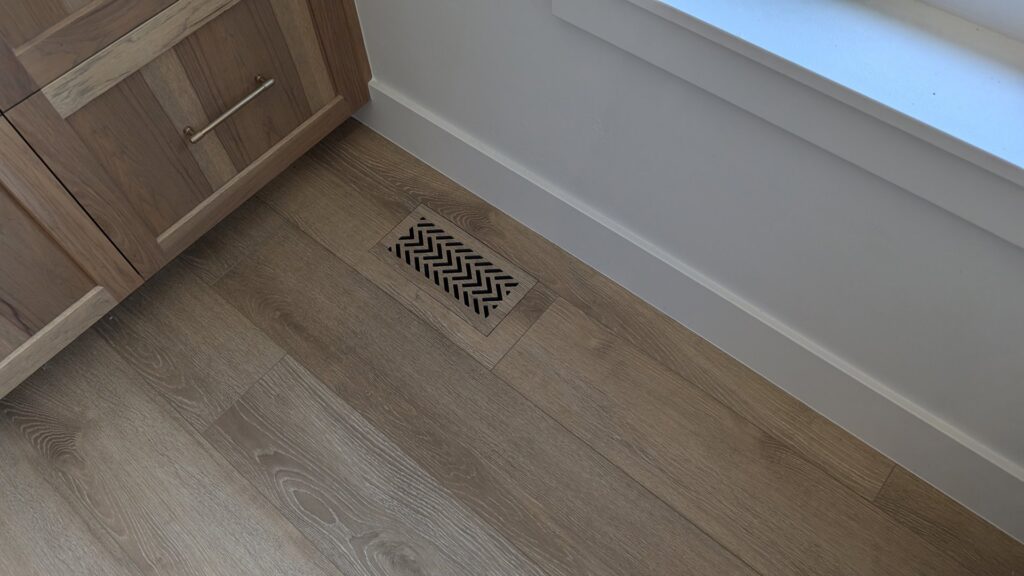 An installed floor vent with a modern chevron pattern by BYLT Living, an HVAC contractor in Sandy, UT