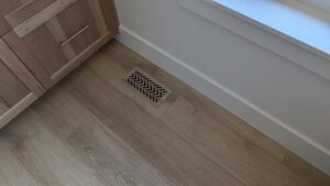 An installed floor vent with a modern chevron pattern by BYLT Living, an HVAC contractor in Sandy, UT