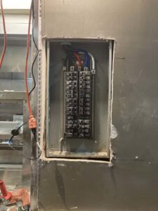 An installed electrical breaker panel with circuit breakers in a wall by Ace Electric Inc. in Valdosta, GA.