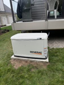 A newly installed Generac standby generator on a concrete pad next to a home by Electric R US LLC in Dearborn, MI.