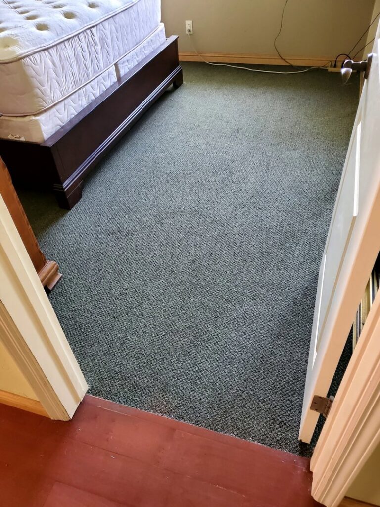 A bedroom featuring newly installed green carpet, a completed residential project by Anaheim Carpet and Flooring in Anaheim, CA.