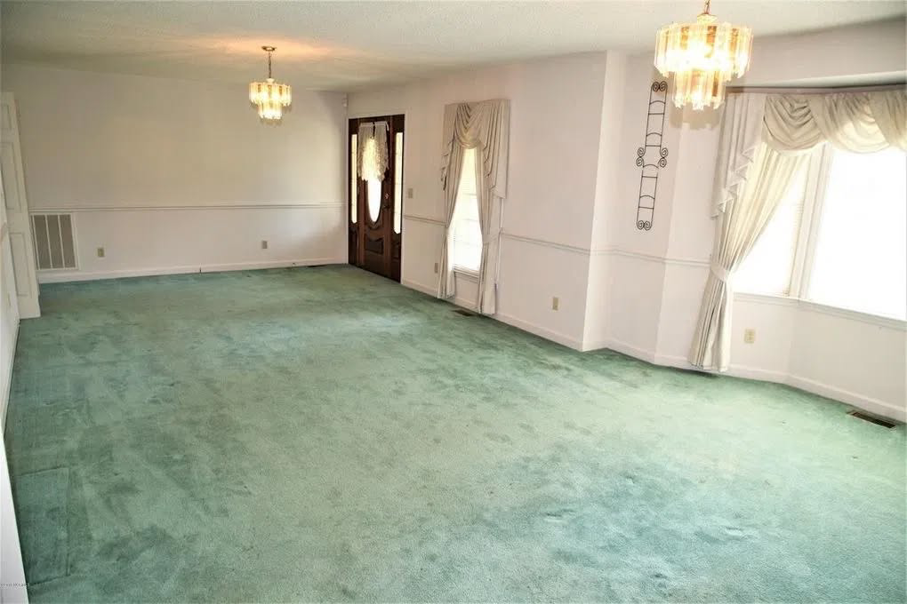A spacious living room featuring newly installed green wall-to-wall carpet by Coweta Carpet Center in Coweta, OK.