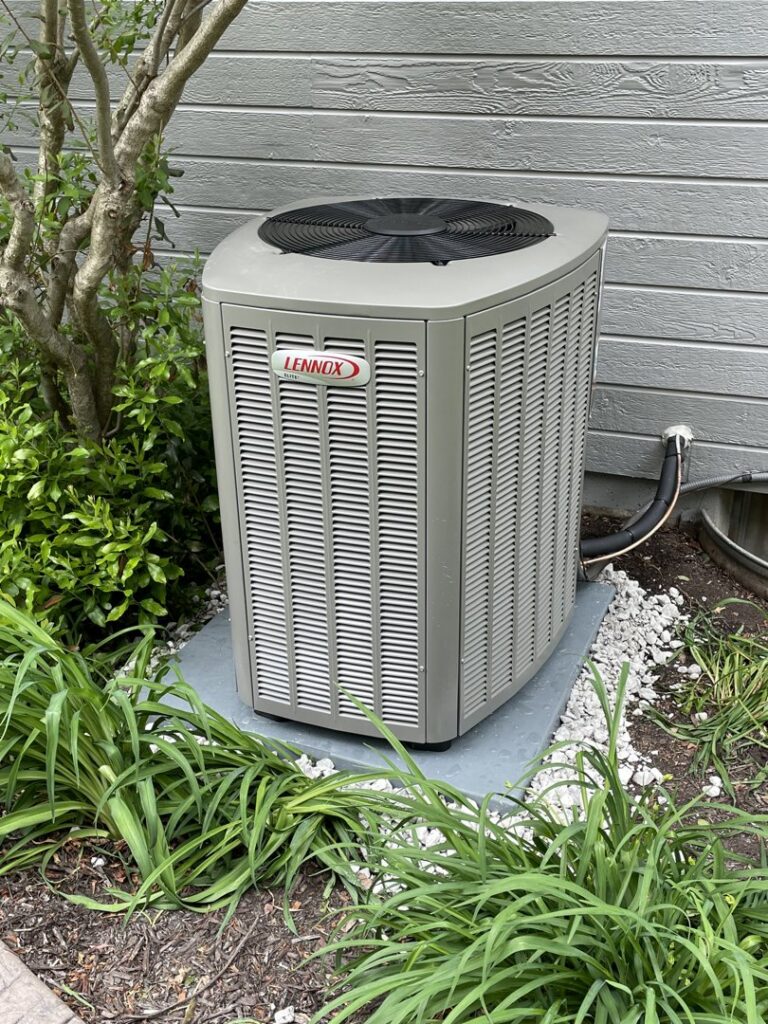An installed Lennox air conditioning unit next to a residential building by Davenport Service Company in Olathe, KS