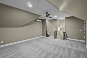 A spacious room featuring newly installed light gray carpet by Shop At Home Carpets in Bowling Green, KY.