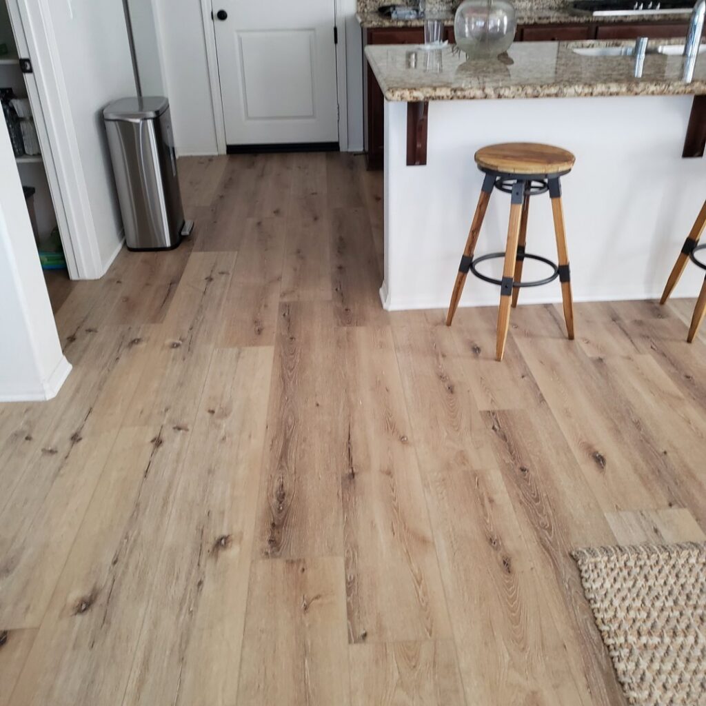 A kitchen area showcasing newly installed light wood-look flooring, a completed project by Anaheim Carpet and Flooring in Anaheim, CA.