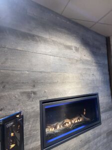 An installed linear gas fireplace with blue flames by Wood Stoves For Sale in Fairbanks, AK.