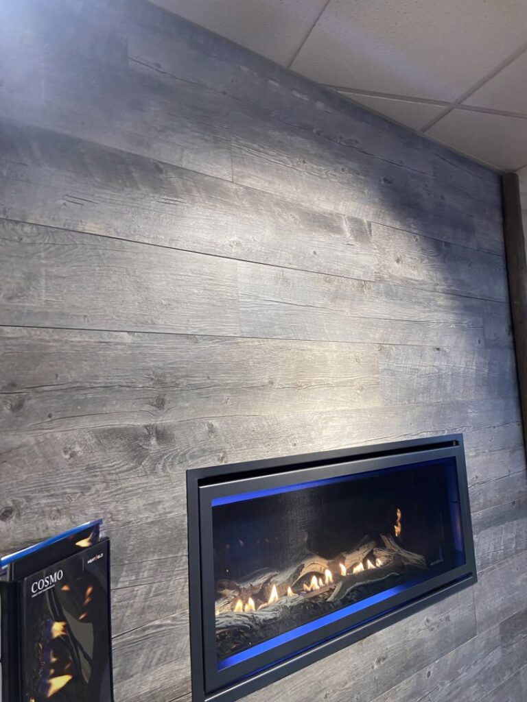 An installed linear gas fireplace with blue flames by Wood Stoves For Sale in Fairbanks, AK.