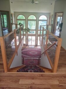 An overhead view of a home interior featuring an installed oriental rug runner on stairs and a large area rug below by Borokhim's Oriental Rugs in Madison, WI.