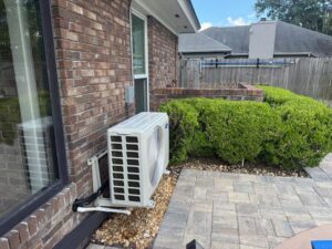A newly installed outdoor mini-split air conditioning unit on the side of a brick house by Whitleys Heating and Air in Jacksonville, FL.