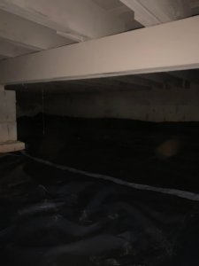 An installed black vapor barrier covering the floor of a crawl space by Buzz Pest Control in Springfield, MO.