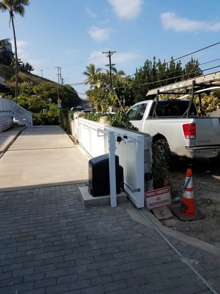 A newly installed white automatic sliding gate for private property by Upright Fencing Hawaii LLC in Kapolei, HI.
