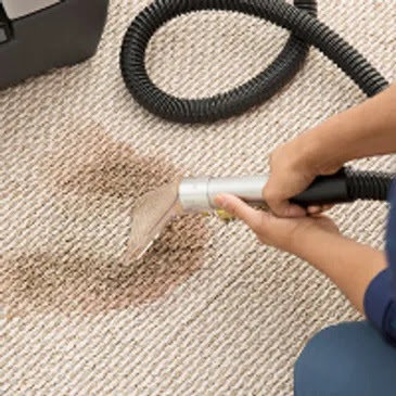 A carpet contractor installing a metal transition strip with a drill, a service by Alpine Carpet Care in Medford, OR.