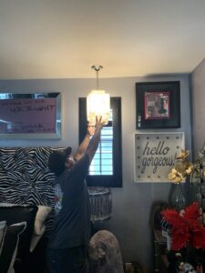 An electrician installing a new ceiling light fixture for Steve Cavenee Electric in Orange, CA.